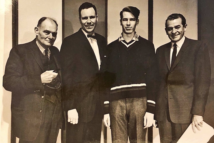 An old photograph of three older men and one teenaged boy