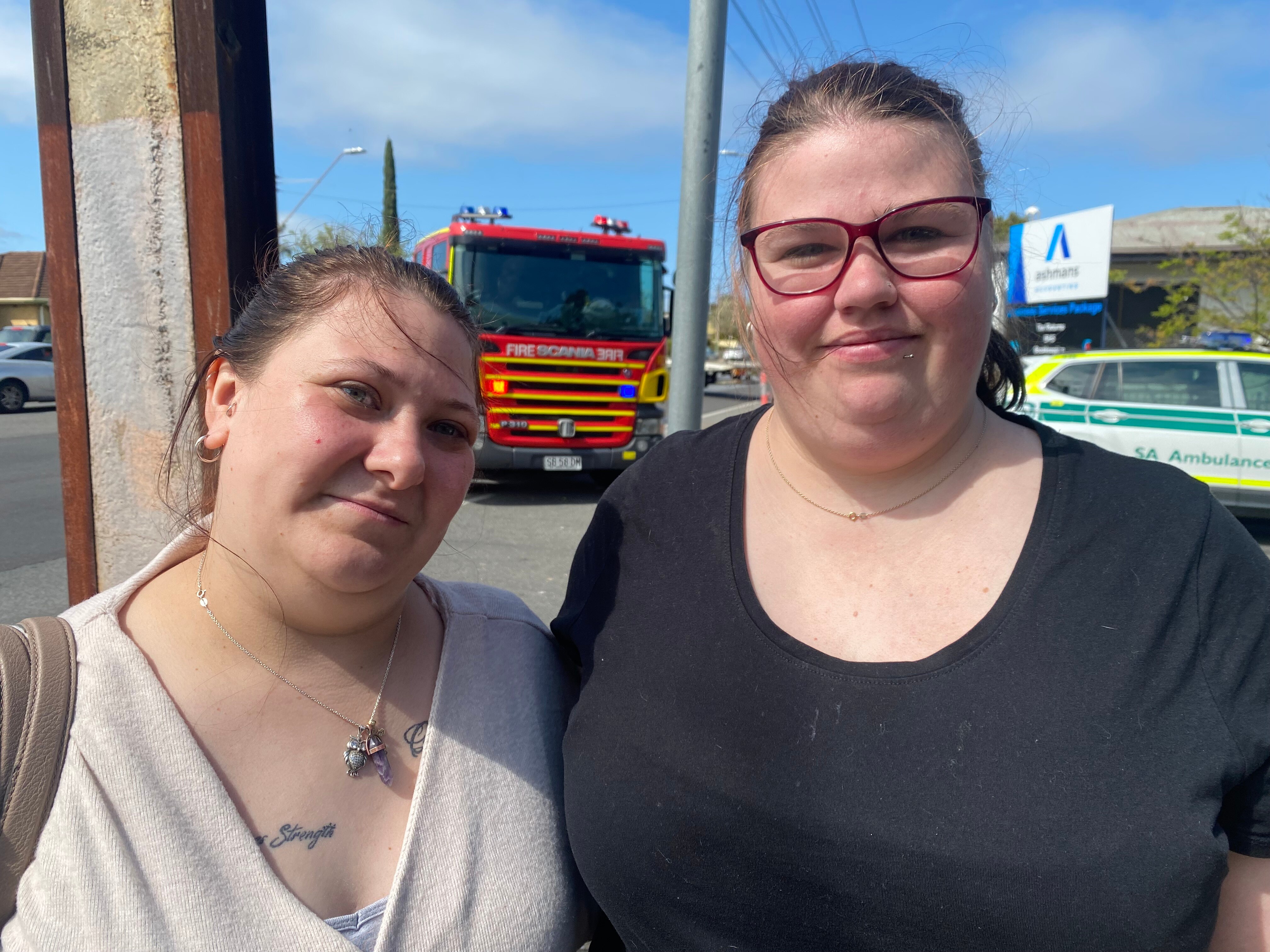 Two women with a fire engine behind them