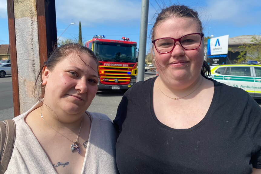 Two women with a fire engine behind them