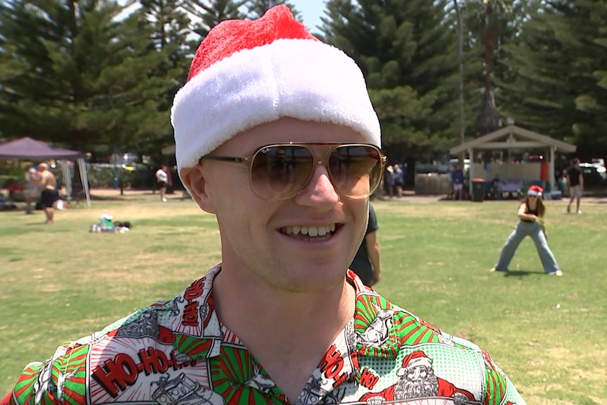 a man wearing a santa hat and sun glasses
