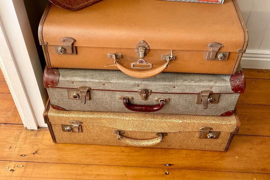 A collection of old 1940s era suitcases stacked on top of each other. 
