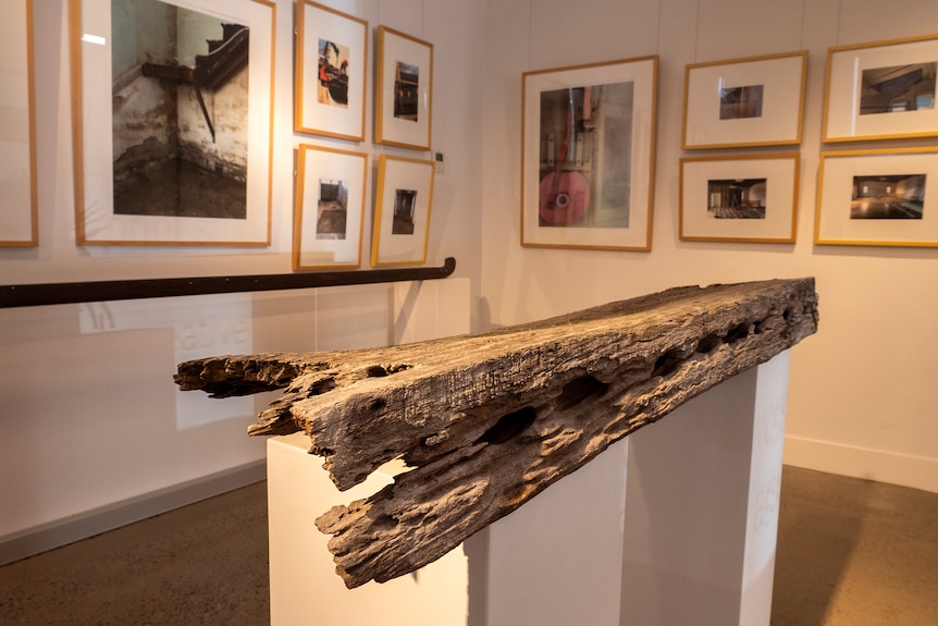 An original timber beam from the building is displayed like an artwork.