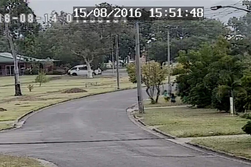 Security camera image of a suburban street with children playing beside the road
