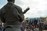 A member of the Islamist Al Shabaab militant group stands watch over Somalis at an aid-distribution camp in southern Mogadishu.