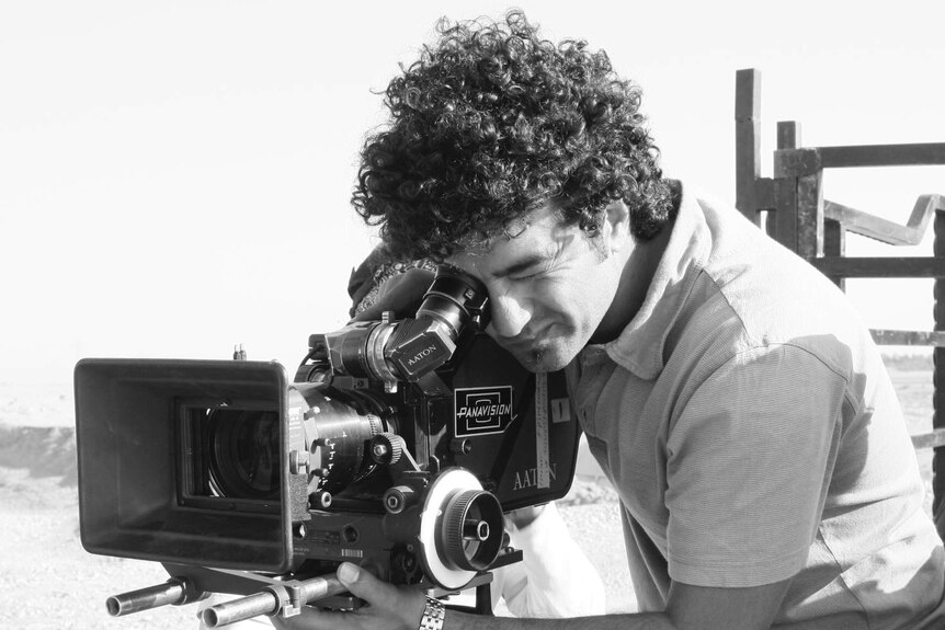 Filmmaker Mohamed Al-Daradji looking into video camera.