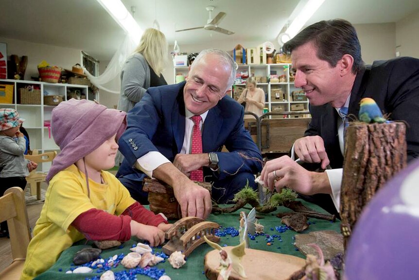 Malcolm Turnbull and Simon Birmingham at childcare centre, playing with a small child.