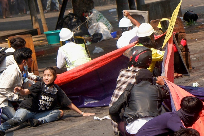 Protesters lie on the ground after police opened fire.