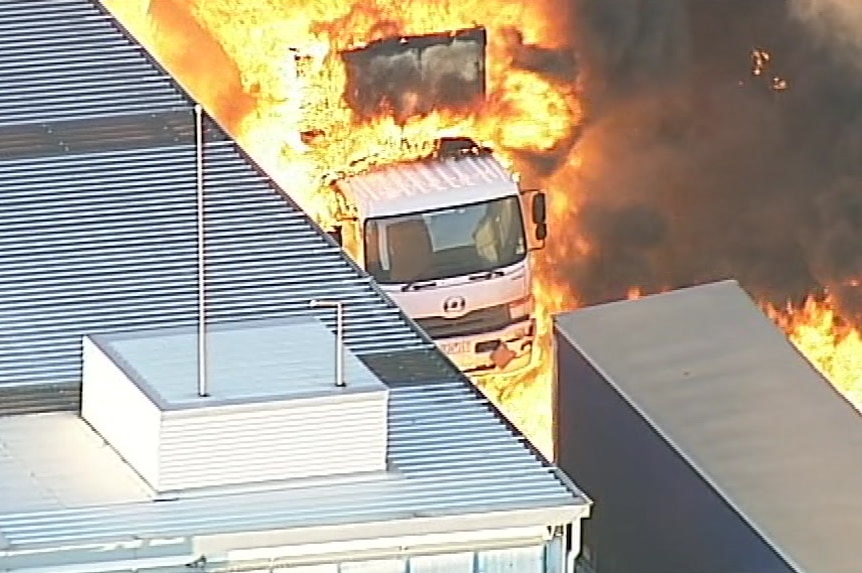 Orange flames engulf a truck as the factory fire rages.