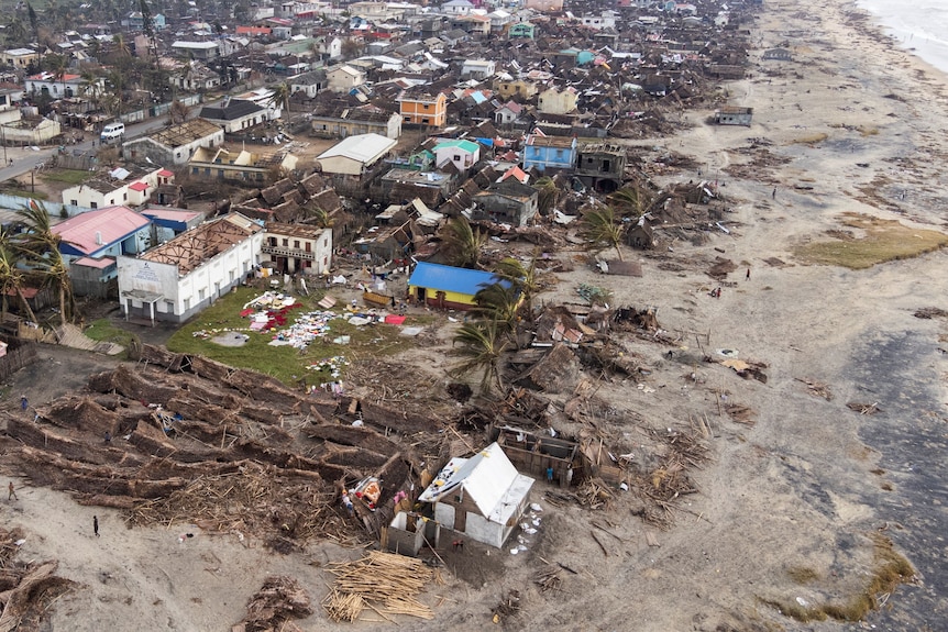 Aerial shot of damaged houses and debris on the beach.