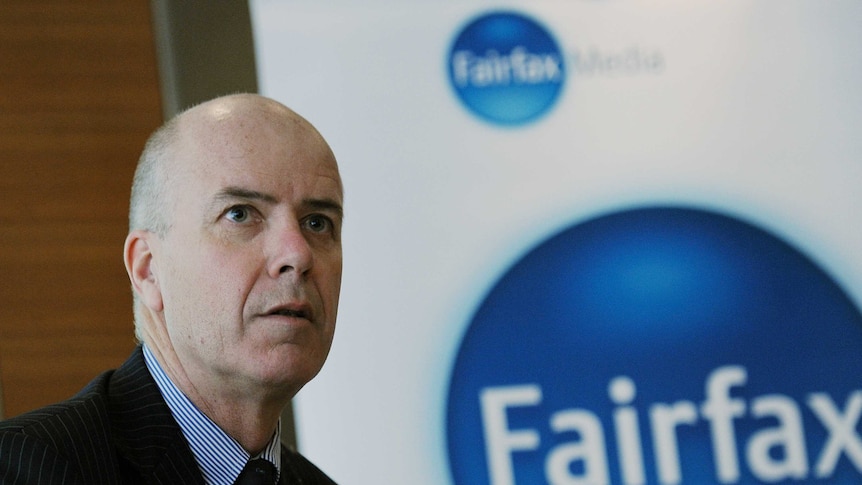 Greg Hywood stands next to a Fairfax logo before delivering a media conference in Sydney.