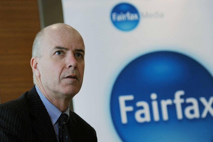 Greg Hywood stands next to a Fairfax logo before delivering a media conference in Sydney.