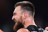 A Port Adelaide AFL player pumps his fists as he celebrates a goal against Western Bulldogs.