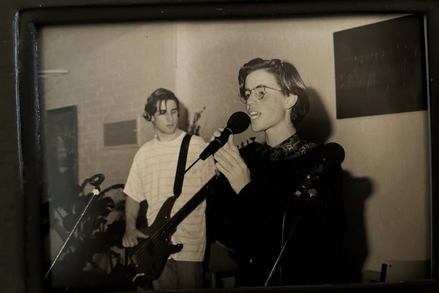Two boys in their late teens performing on stage. Doctor Paul is at the microphone, the other plays guitar