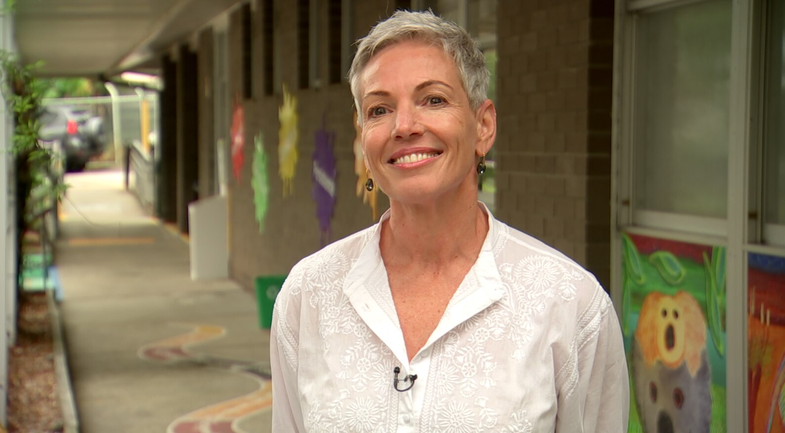 Kim Witt standing in front of a school building smiling 