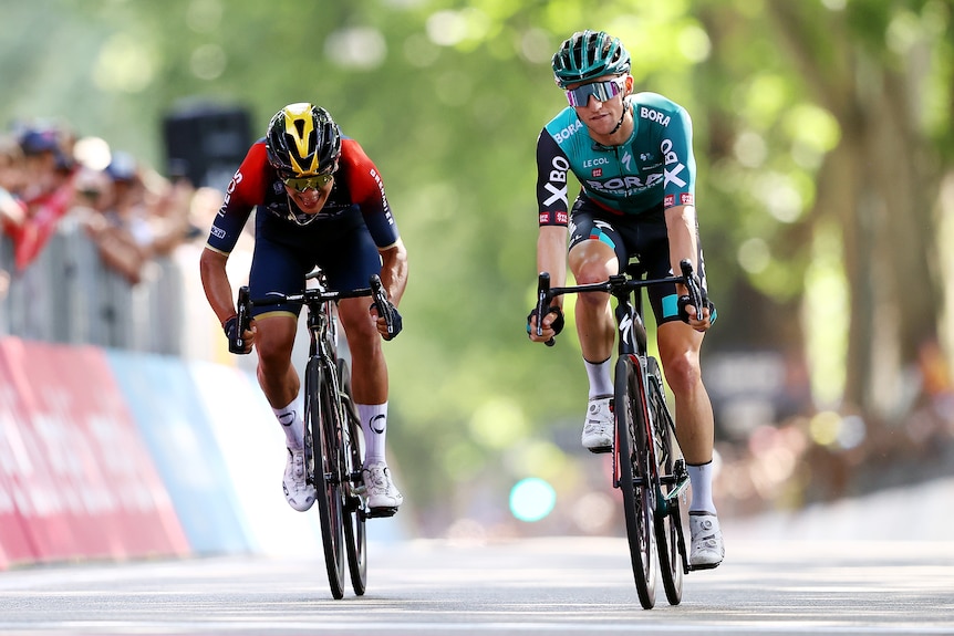 Richard Carapaz and Jai Hindley ride their bikes next to each other