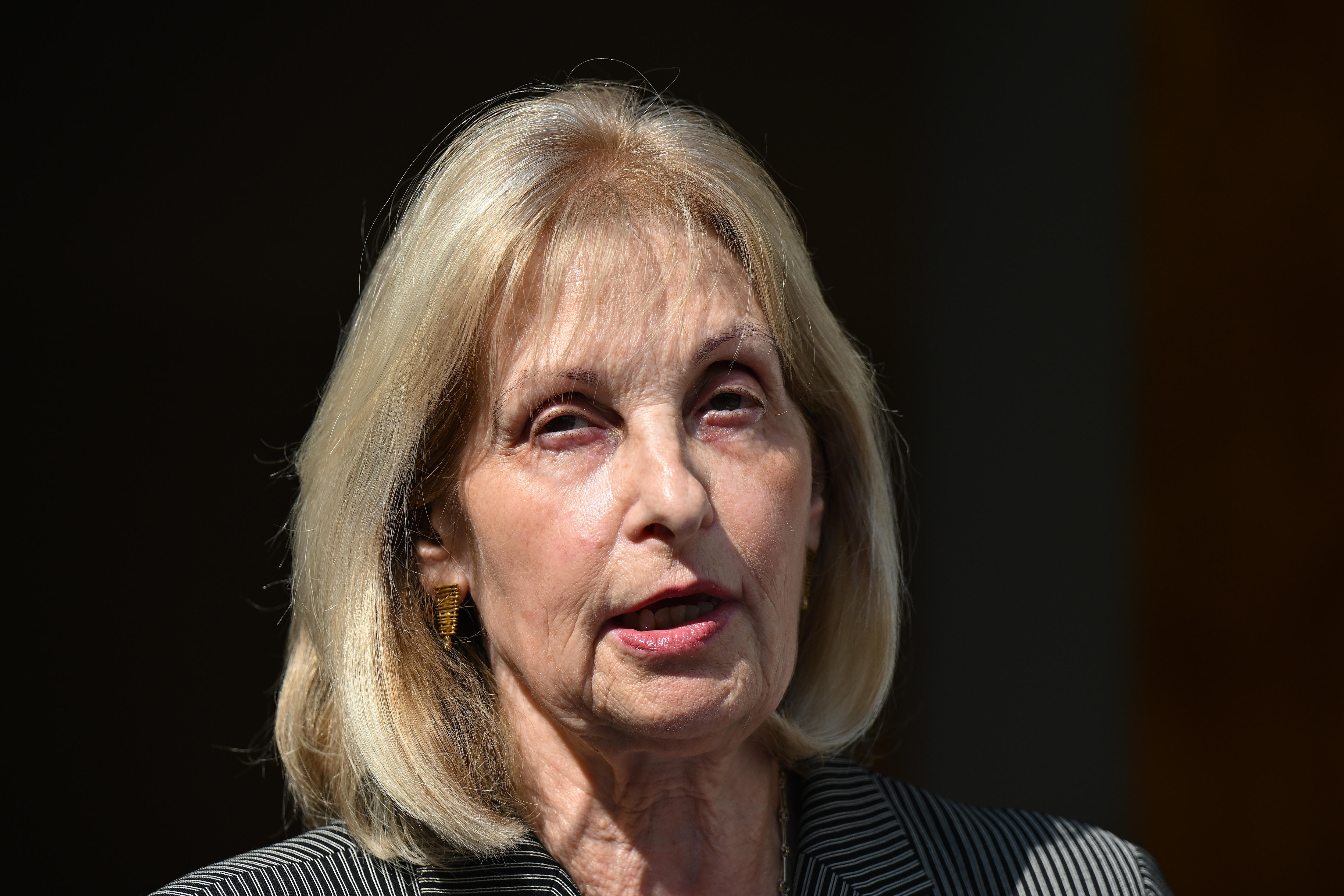 A middle-aged, blonde woman in mid-sentence.
