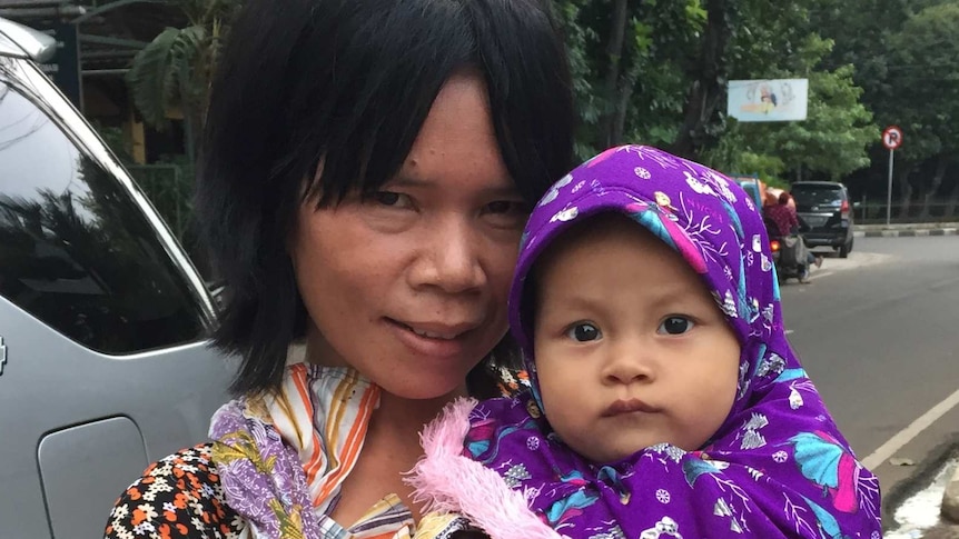 Dewi carries her nine month-old baby Sabrina