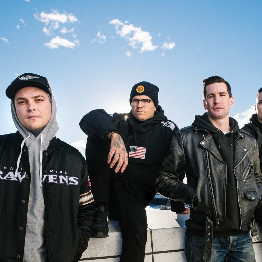 The members of The Amity Affliction stand on a sunny rooftop