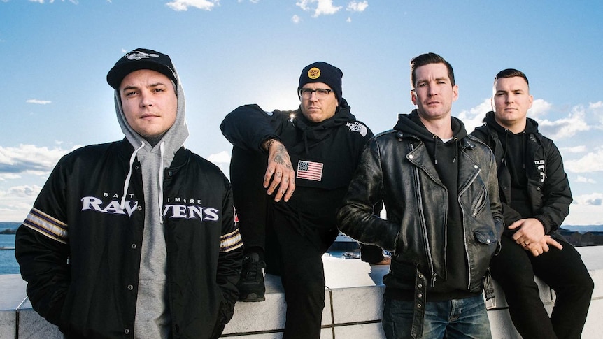 The members of The Amity Affliction stand on a sunny rooftop