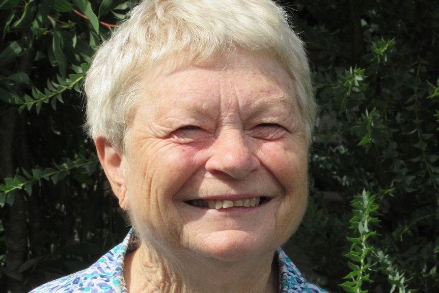 A woman with short hair smiles.