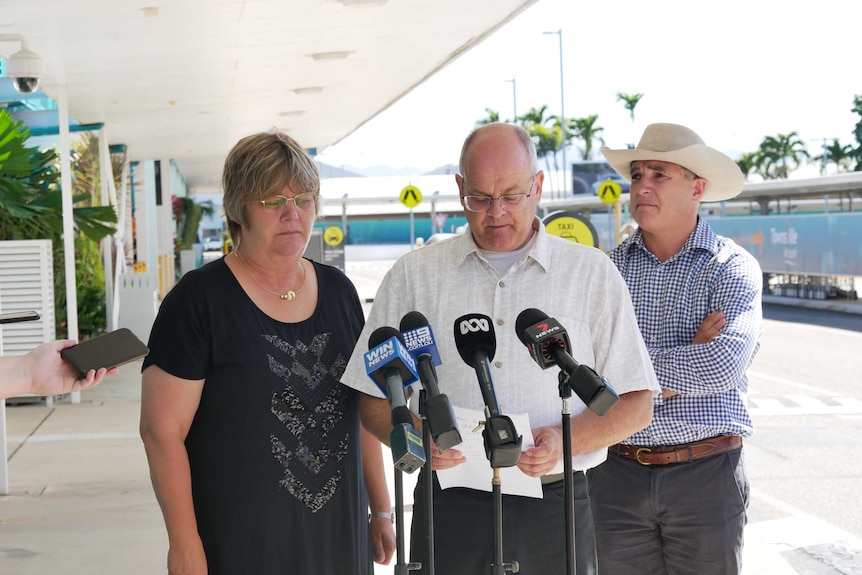 A family of three people looking at the camera