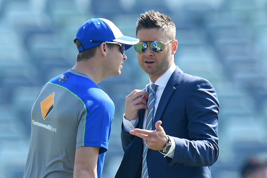 Former Australian captain Michael Clarke (R) speaks to skipper Steve Smith on day one at the WACA.