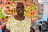Priscilla Major stands in front of artwork on display at the Kowanyama State School Library.