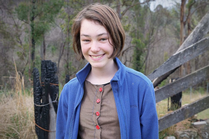 14 year old girl smiling in a bush setting.