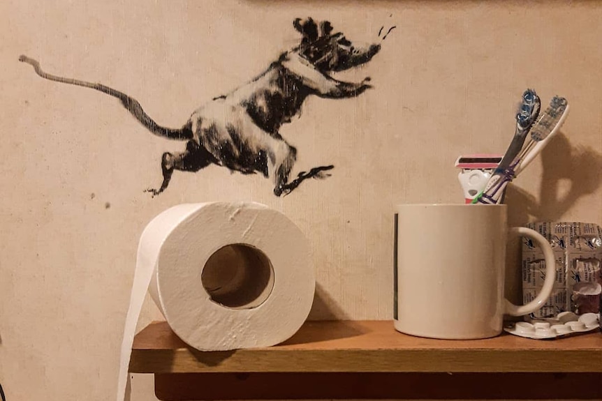 Une peinture d'un rat coule sur un rouleau de papier toilette dans une salle de bain.