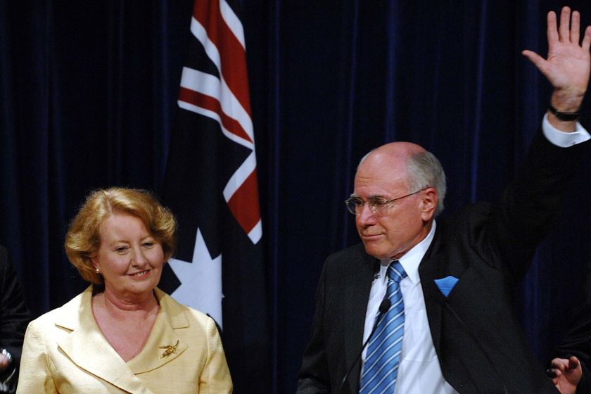 John Howard waves farewell as he stands next to his wife Janette.