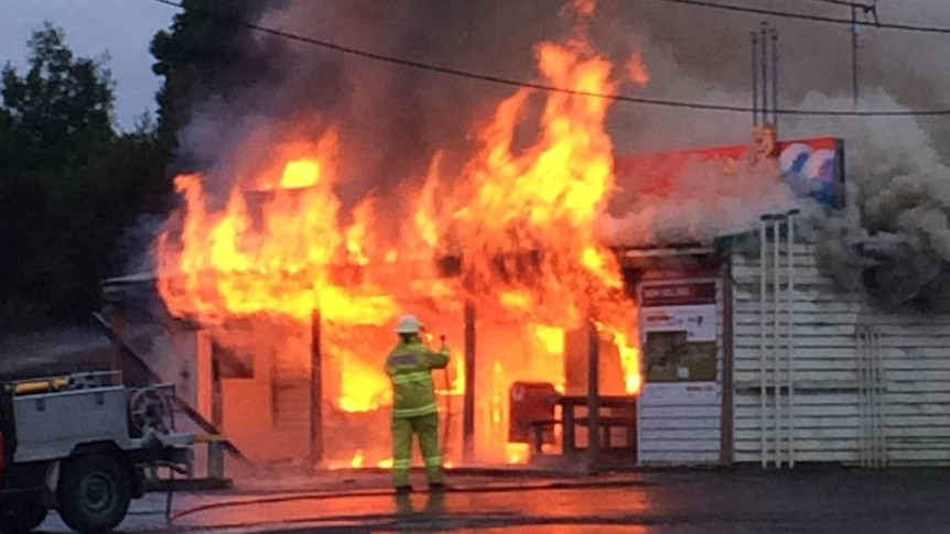 Firefighters attempt to put out the blaze engulfing the Port Arthur general store.