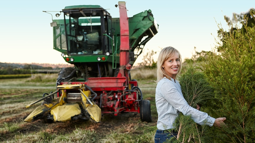 Dee-Anne Prather stands in the tea tree field with a tractor.