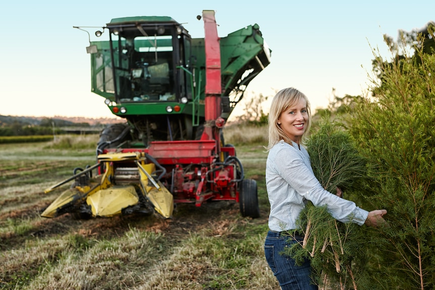 Dee-Anne Prather stands in the tea tree field with a tractor.