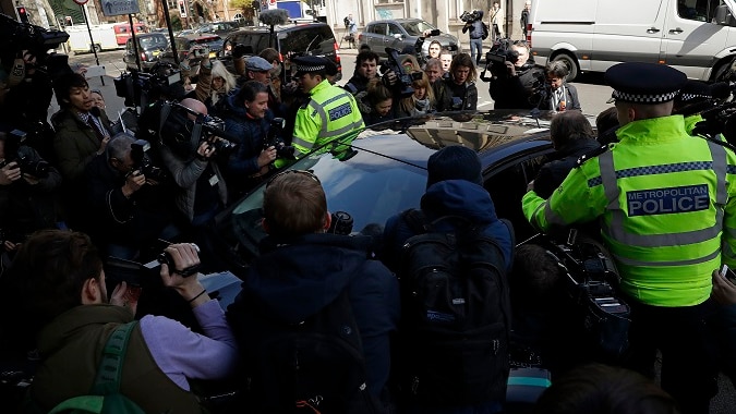 Media waiting for the arrival of WikiLeaks founder Julian Assange swarm around a car.