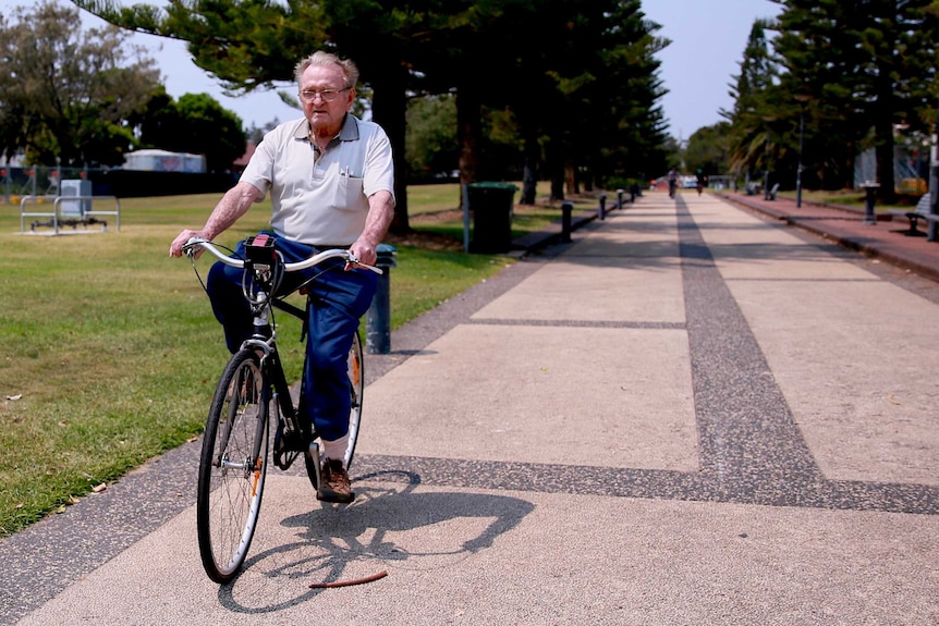 Desmond White rides a bike in a park in Newcastle.