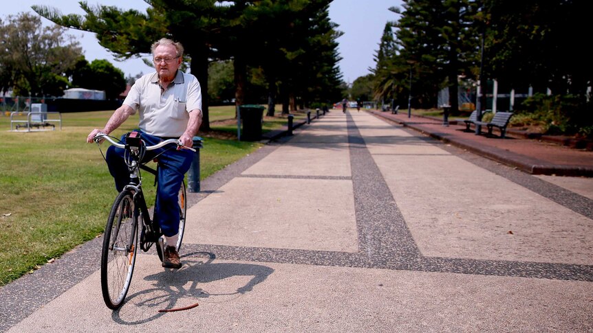 Desmond White rides a bike in a park in Newcastle.