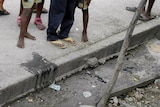 A Haitian resident suffering from cholera waits for help on a street