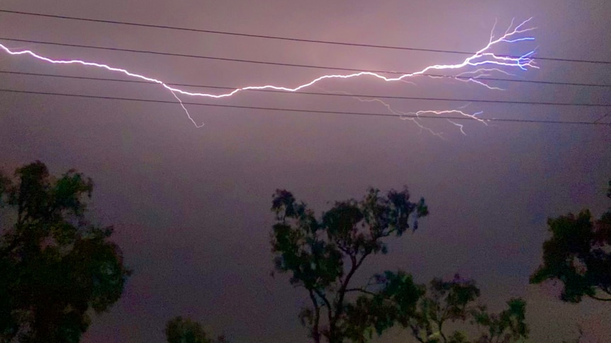 A lightning bolt lances horizontally through a stormy sky.