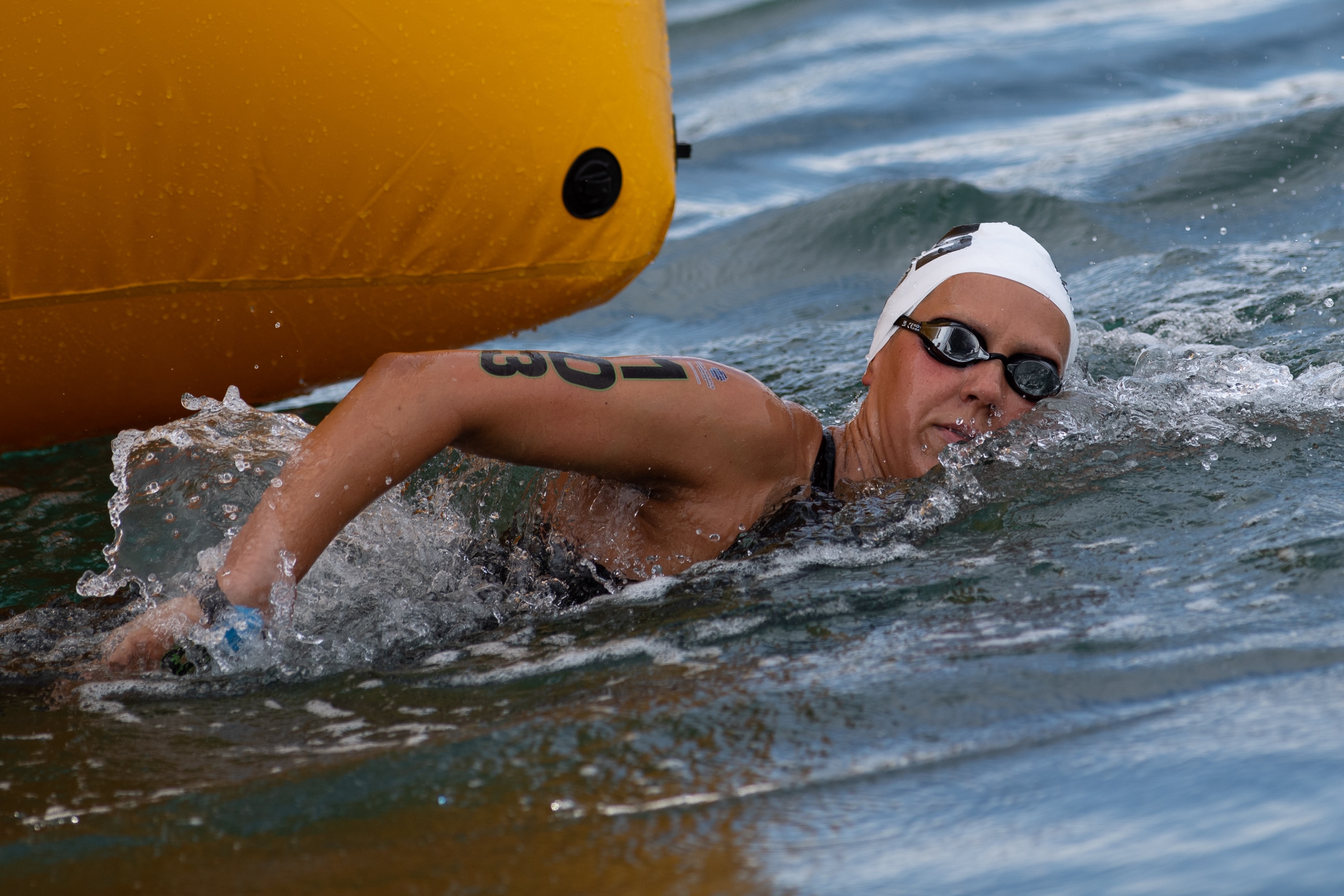 Moesha Johnson swims next to a yellow buoy