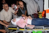 A Syrian woman who was wounded following a reported shelling by rebel fighters arrives on a stretcher to a hospital.