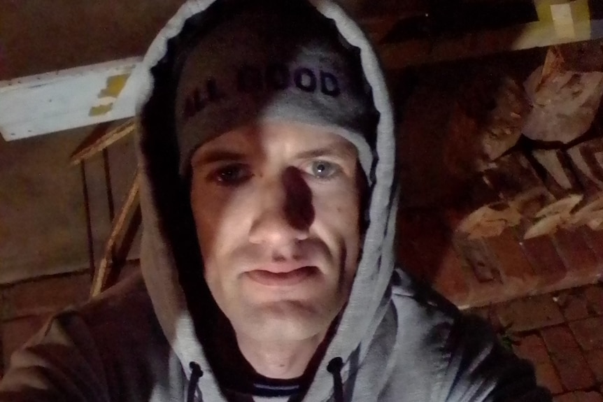 A caucasian man wearing a grey beanie and hoodie.