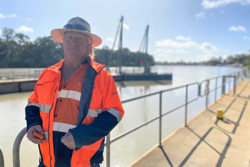 A man with high vis standing in front of a river