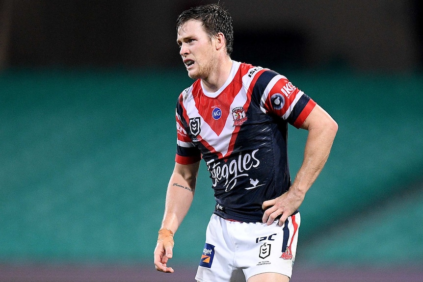 A Sydney Roosters NRL player grimaces as he attempts to walk during a match against the Melbourne storm.