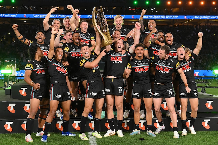Penrith celebrates winning the 2023 NRL grand final with the premiership trophy.