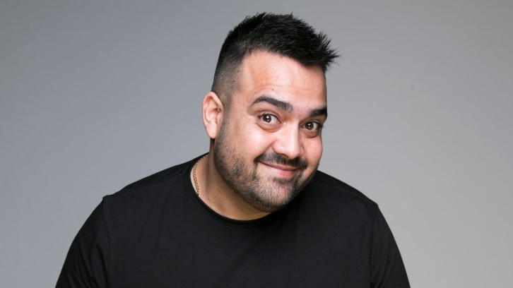 Dane Simpson in black t-shirt in front of grey background.