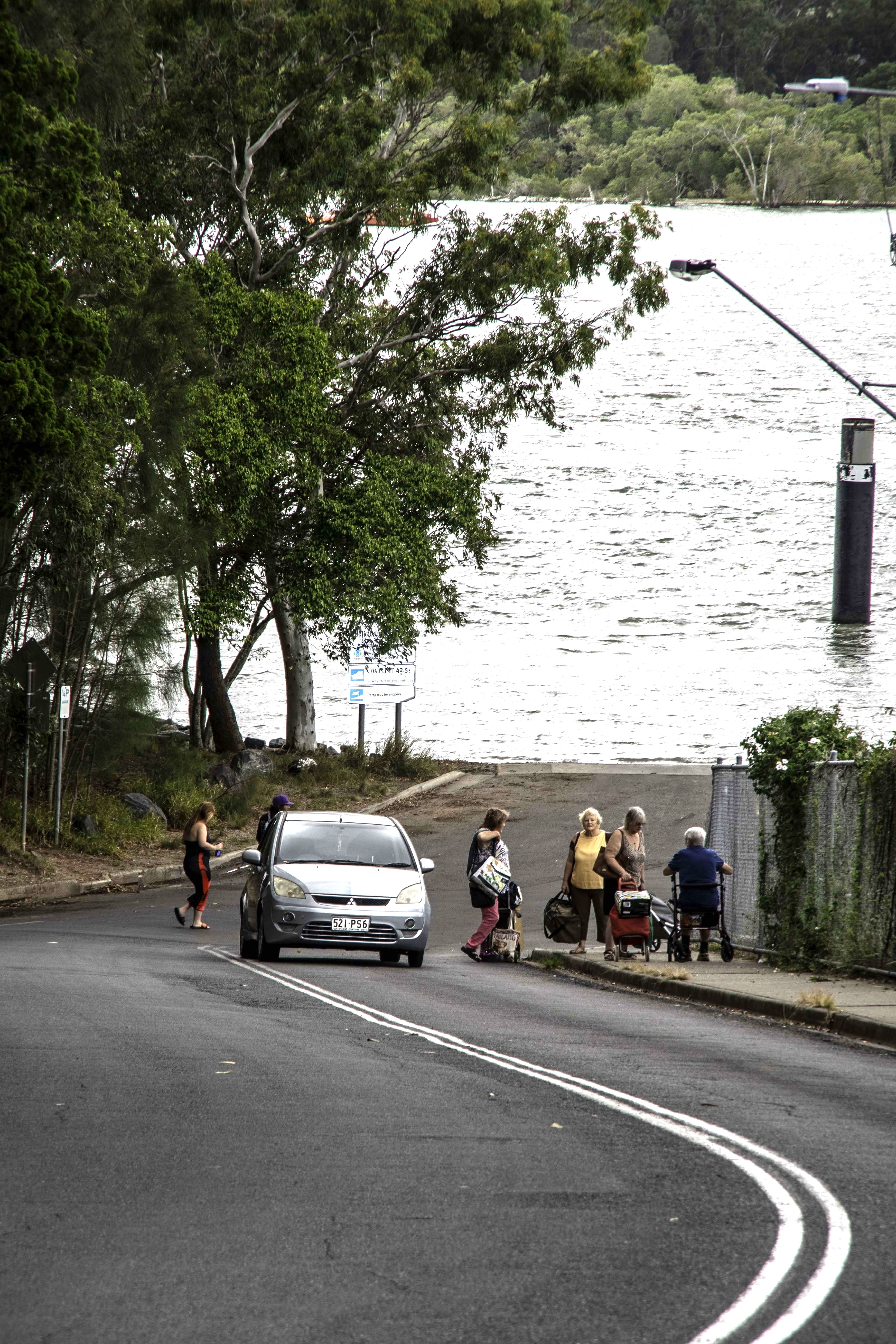 Six people and one car at the bottom of a hill.