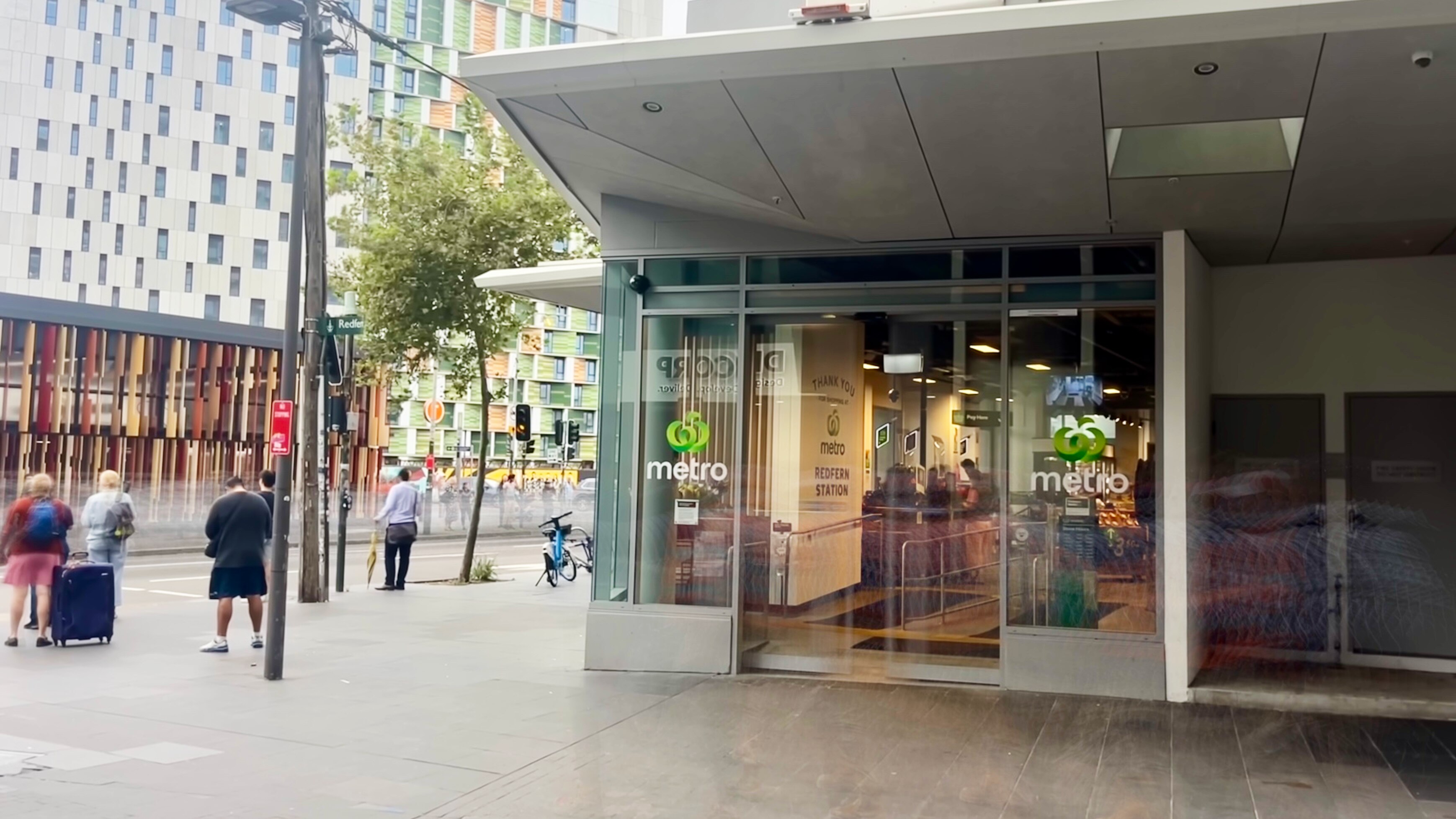 The exterior of a Woolworths metro store, which Redfern station in the background.