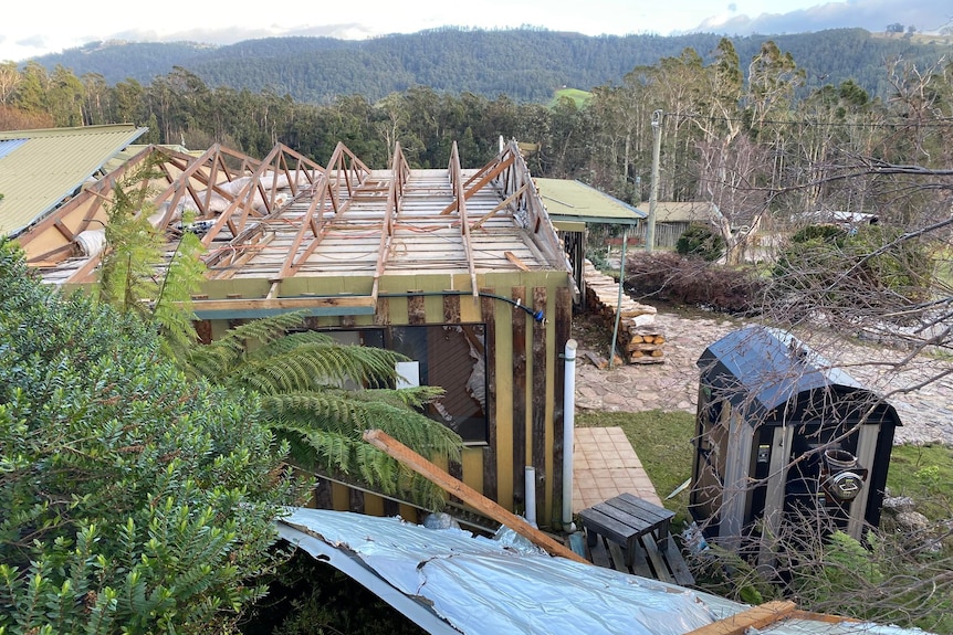 A cabin is partially missing its roof after strong winds.