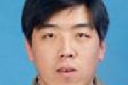Small headshot of Wang Xuefeng, against a blue background. He has black hair and is wearing a light brown jacket.