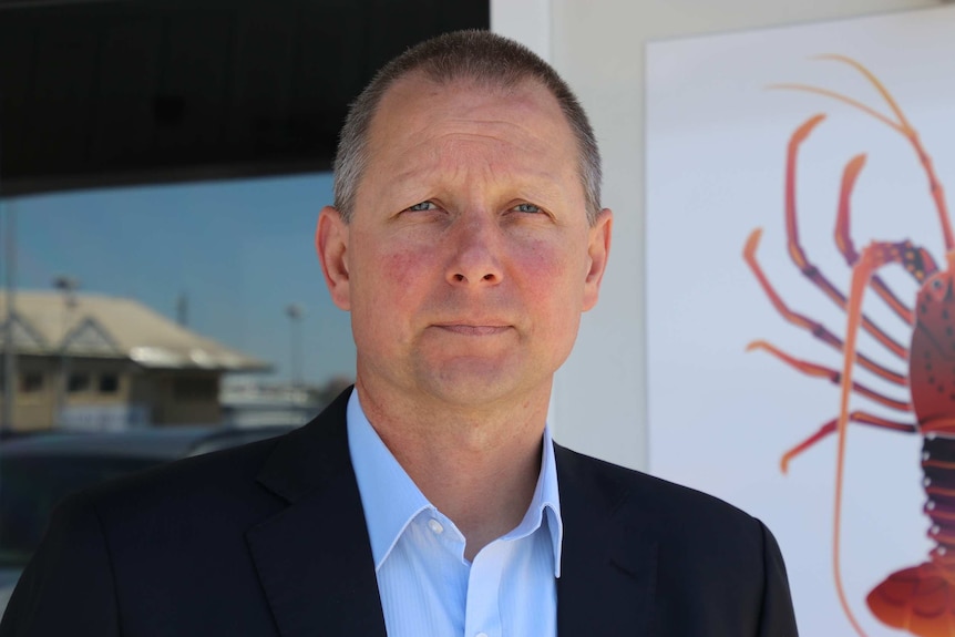 A close-up of Matt Taylor standing  in front of the Western Rock Lobster office.